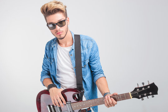 artist playing guitar in studio background