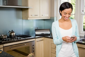 Smiling brunette using smartphone