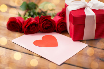 close up of gift box, red roses and greeting card