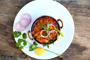 Butter chicken mutton curry or Indian style cottage cheese curry in a brass bowl with Salads.