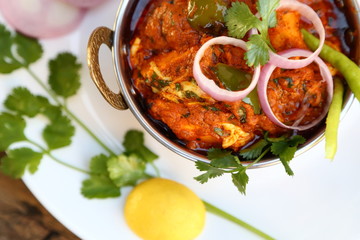 Butter chicken mutton curry or Indian style cottage cheese curry in a brass bowl with Salads.