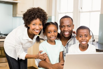 Happy family using laptop in the kitchen