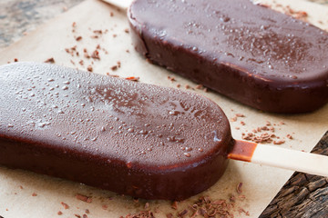 popsicle with grated chocolate on wooden background close-up