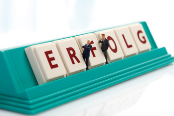 Geschäftsleute Figuren, Scrabble Fliesen bilden die Wort Erfolg