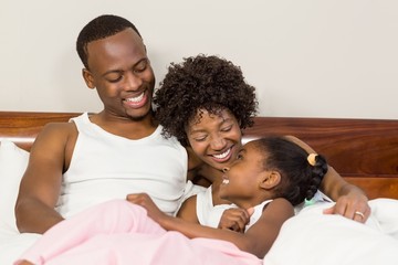 Obraz premium Happy family lying in bed together