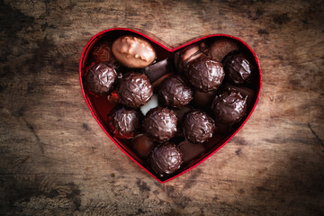 Studio, Karton in Herzform mit Trüffeln auf einem Holzuntergrun