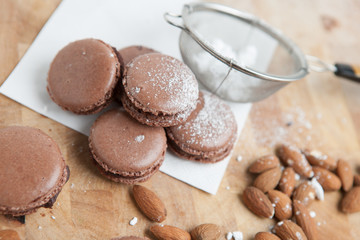 Selbstgebackene Makronen, Mandeln, Puderzucker und Sieb