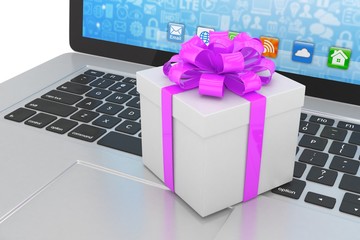 Gift box with ribbon on laptop keyboard