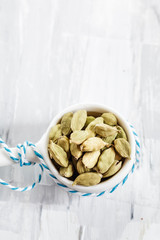 Grüne Kardamomkapseln in kleinem Stieltopf