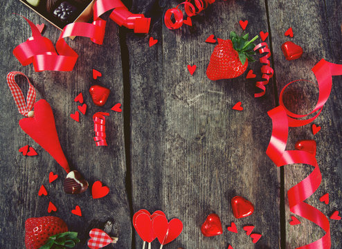 hearts, chocolate, flowers and ribbons on wooden surface