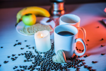 still life of mugs of coffee, coffee beans, and hearts of wood horizontal in evening blue tones