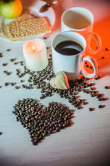 still life of mugs of coffee, coffee beans, and hearts of wood тin warm brown tones