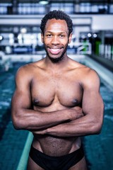 Fit swimmer standing with arms crossed