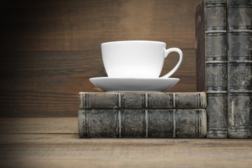 Old Shabby Books And White Cup On The Wood  Background