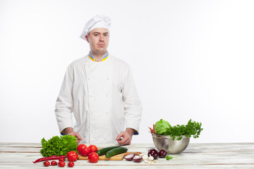 Chef cutting a green cucumber in his kitchen