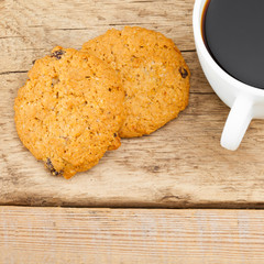Close up of cup of espresso and a cookie on wooden table
