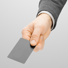 Close up shoot of male holding in hand blank card of grey color