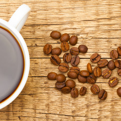 Coffee cup with roasted coffee beans near it - studio shoot