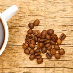 Cup of black coffee with roasted coffee beans near it