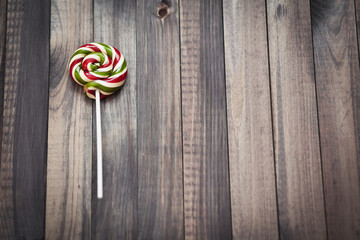 Bright colorful round lollipop wooden background close view from above