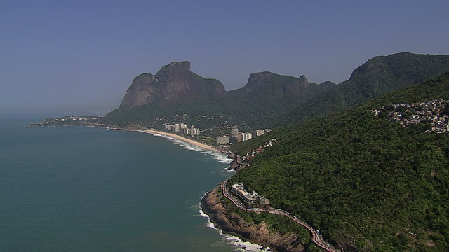 Flying along the mountains to reveal Sao Conrado, Rio de Janeiro, Brazil