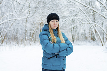 Winter woman in rest snow park. Girl in a turquoise feather bed