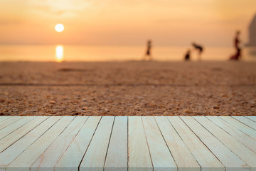 Empty top view of wooden table and view of sunset or sunrise on san beach background.