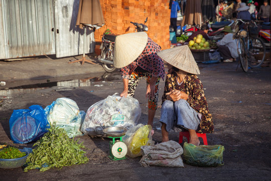 Nha Trang, Vietnam - December 02, 2015: Two vietnamese women are having a conversation at the street market, Nha Trang, Vietnam on December 02, 2015.