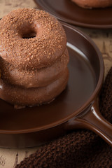 Chocolate homemade donuts on brown newspaper background