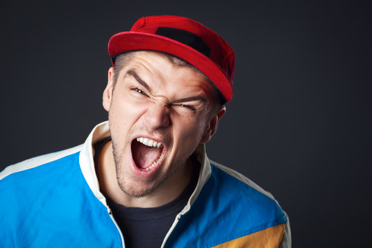 Portrait of screaming young guy in studio.