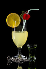 Glass of lemonade with bendie on black mirror background