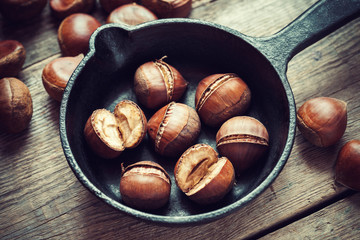 Roasted chestnuts on frying pan. Top view. Retro styled.
