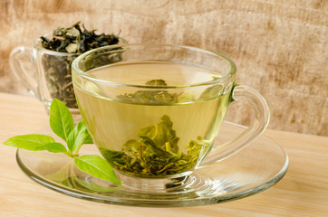 The cup of hot green tea (Healthy drink) on wooden background