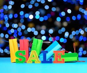 Sale written by colorful letters on the background of shopping b