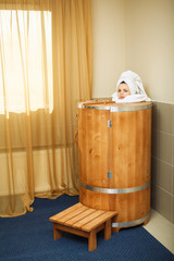 girl in wooden barrels for spa treatments