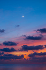 Sunset sky and sea at dusk with crescent moon