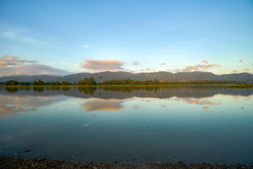 Reflection by the lake with beautiful clouds formation. Nature landscape.