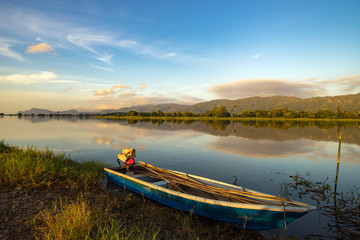 Beautiful morning at the lake with a fishing boat.