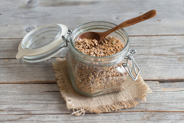 Raw whole spelt in a glass jar