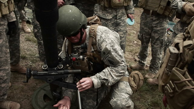 Soldiers aiming a mortar launcher.