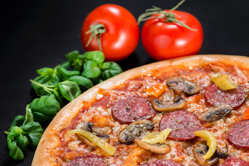 closeup Tasty pizza with tomatoes, mushroom, sausage, basil and