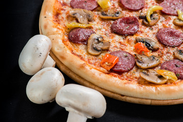 closeup Tasty pizza with mushroom, sausage, basil and chili pepp