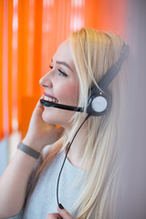 Smiling young business woman wearing a headset answering calls a