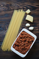 Bolognese sauce with raw spaghetti, parmesan cheese and garlic
