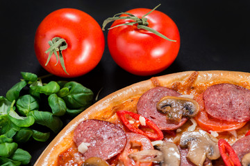 closeup Tasty pizza with tomatoes, mushroom, sausage, basil and