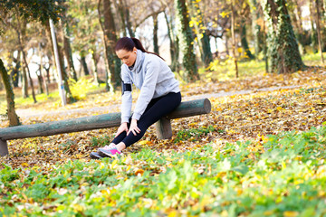 Young woman resting after jogging in park