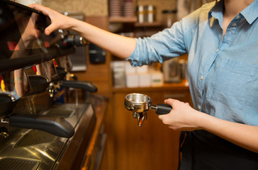 close up of woman making coffee by machine at cafe
