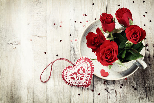 St Valentine's setting with bouquet of red roses in retro mug