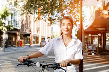 Fototapeta na wymiar Portrait of happy young female bicyclist
