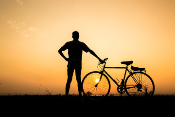 silhouette of  man  and bicycle  on sunset sky